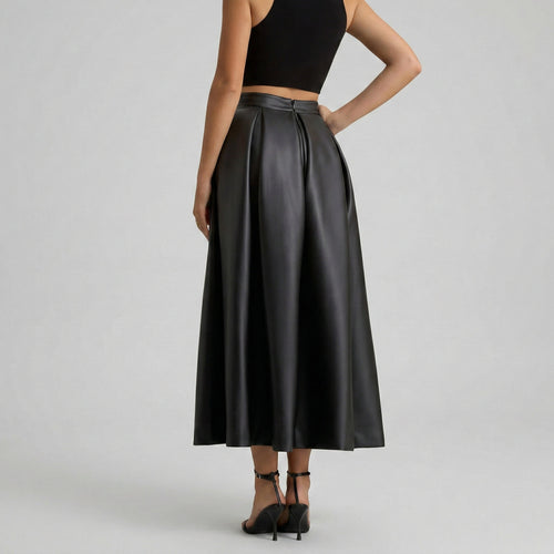 Black leather skirt worn by a person on a gray background