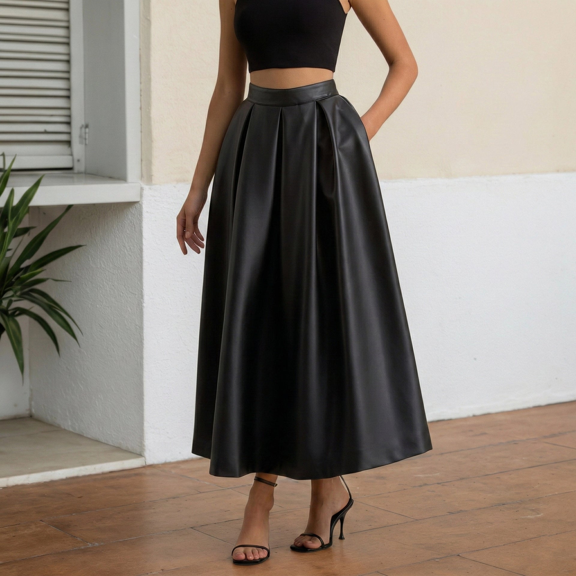 Person wearing a black leather skirt in an outdoor setting