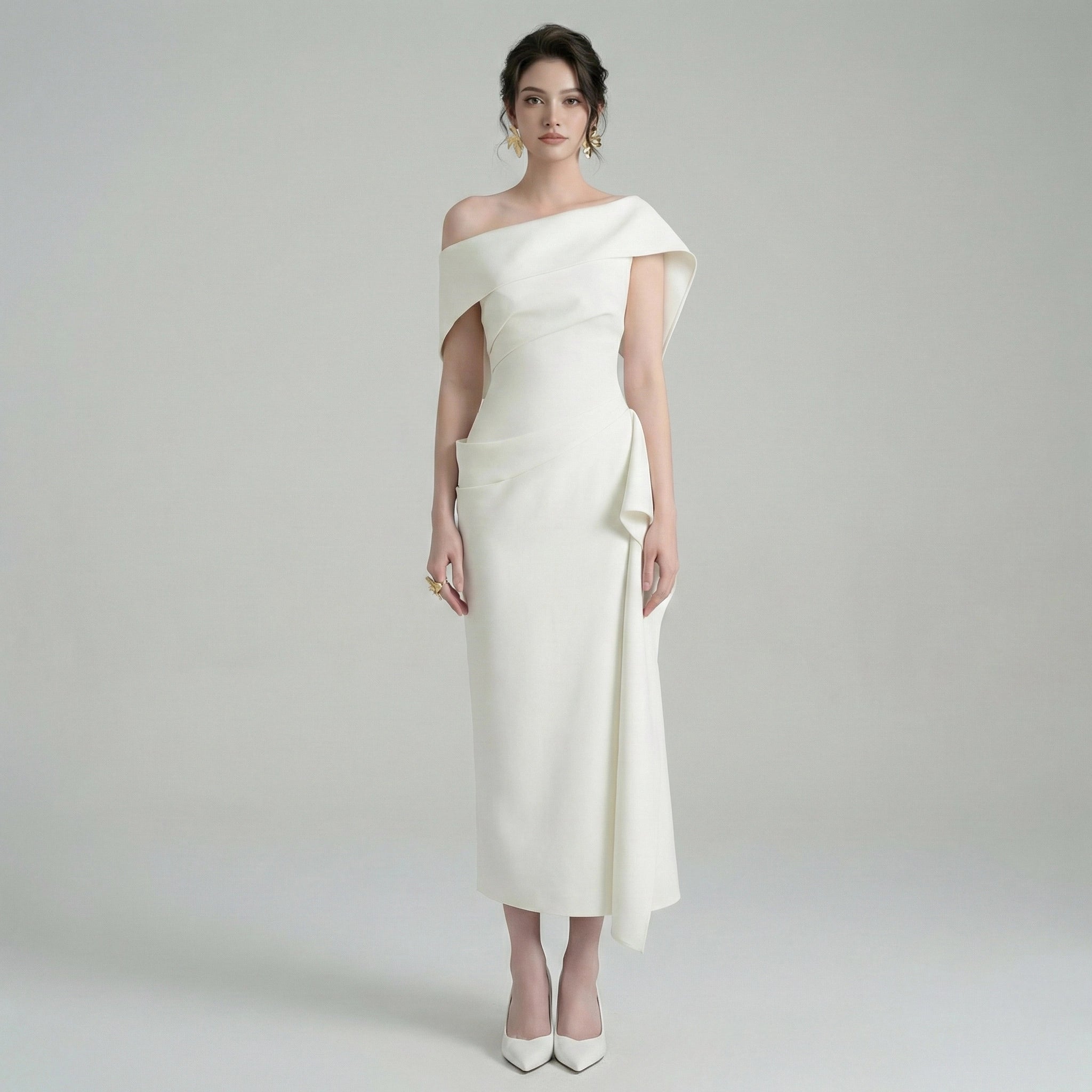 Woman wearing a white one-shoulder dress on a plain background