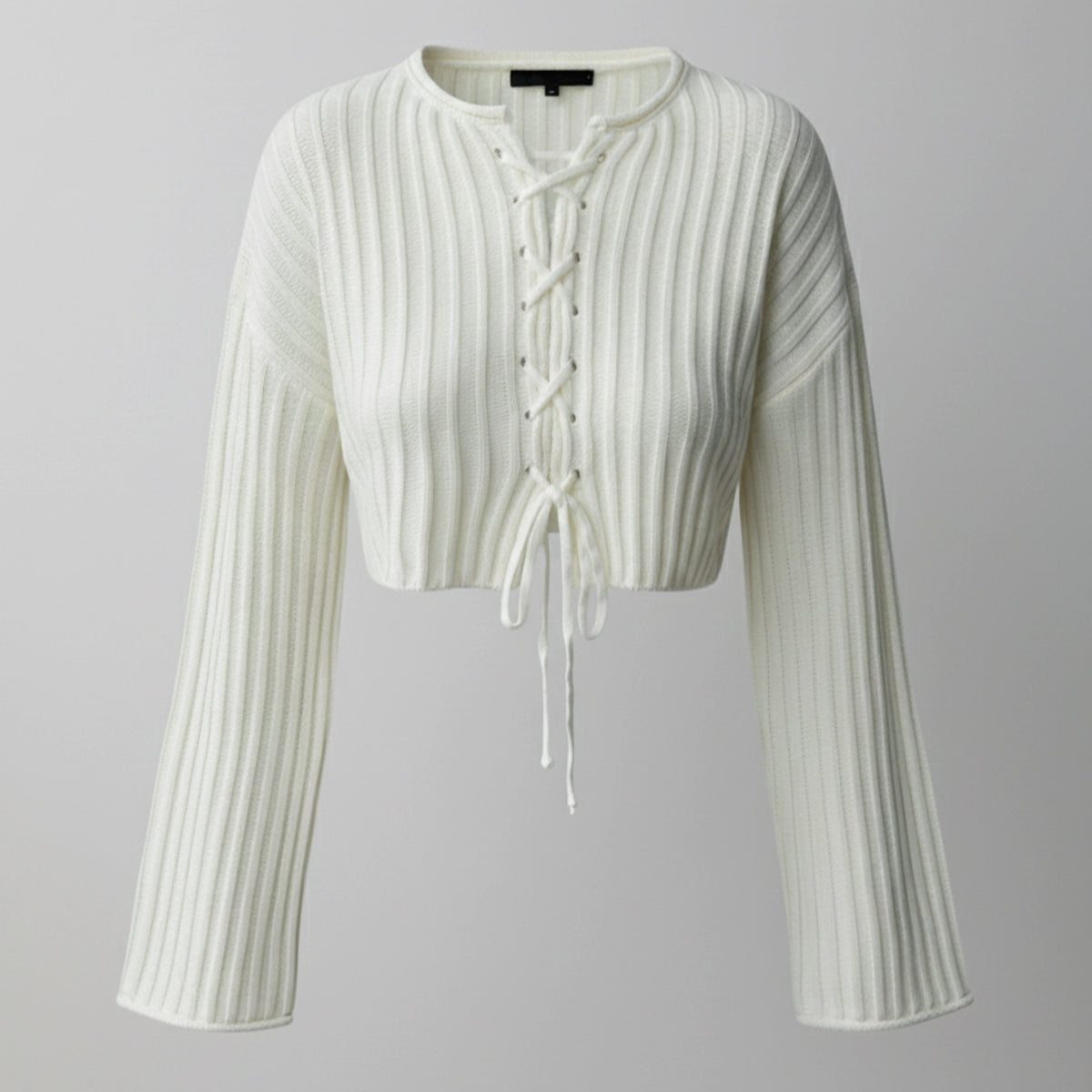 White ribbed knit cardigan with long sleeves on a gray background