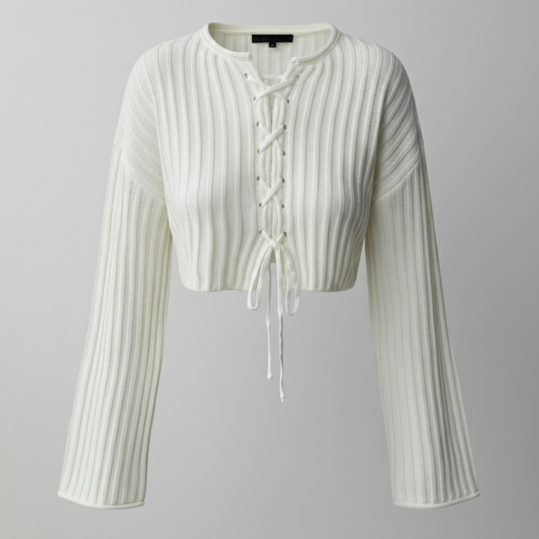 White ribbed knit cardigan with long sleeves on a gray background