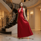 Woman in a red dress standing in an elegant interior setting with a staircase.