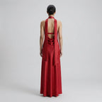 Red evening gown with open back on a plain background
