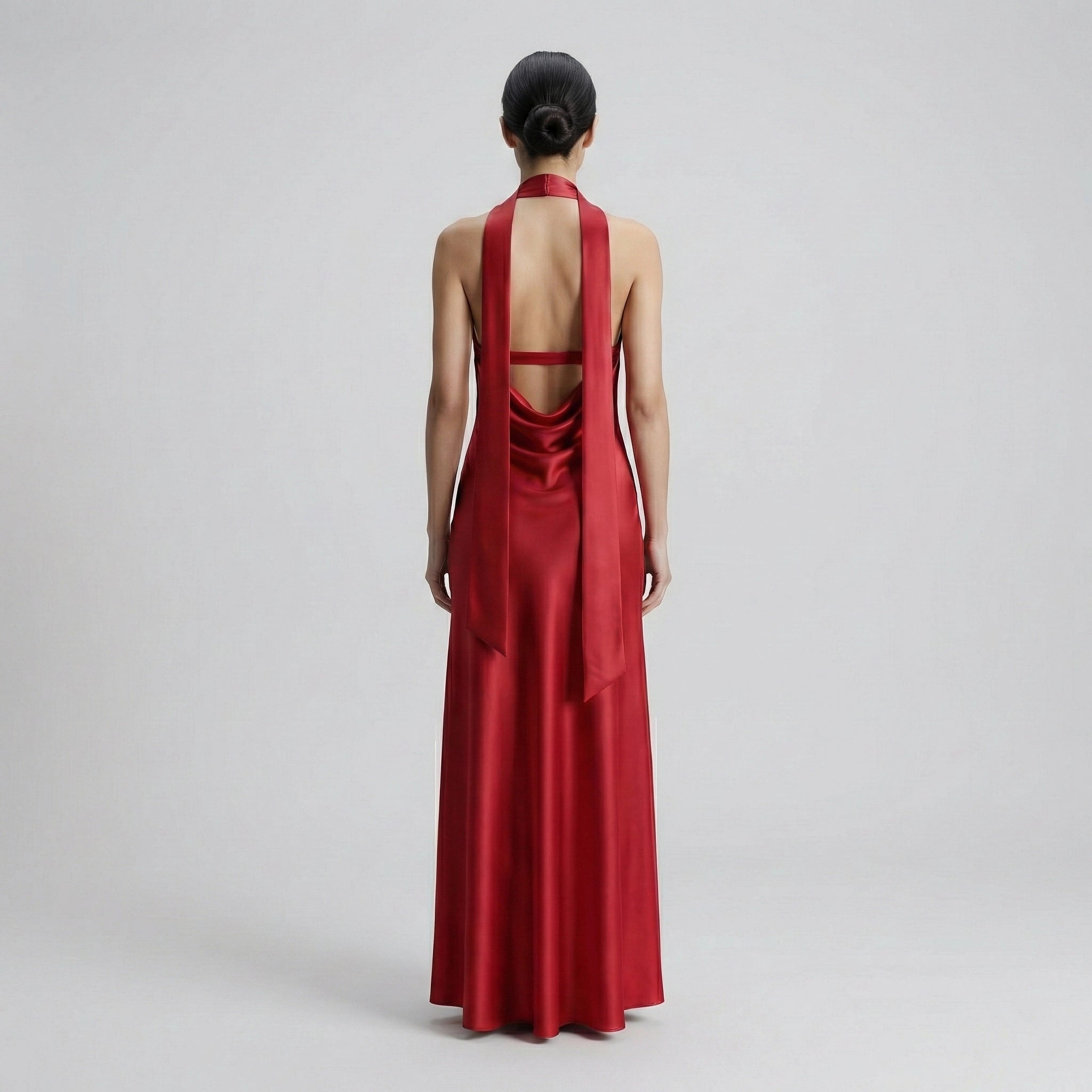 Red evening gown with open back on a plain background