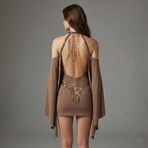 Woman wearing a brown dress with intricate designs on a gray background