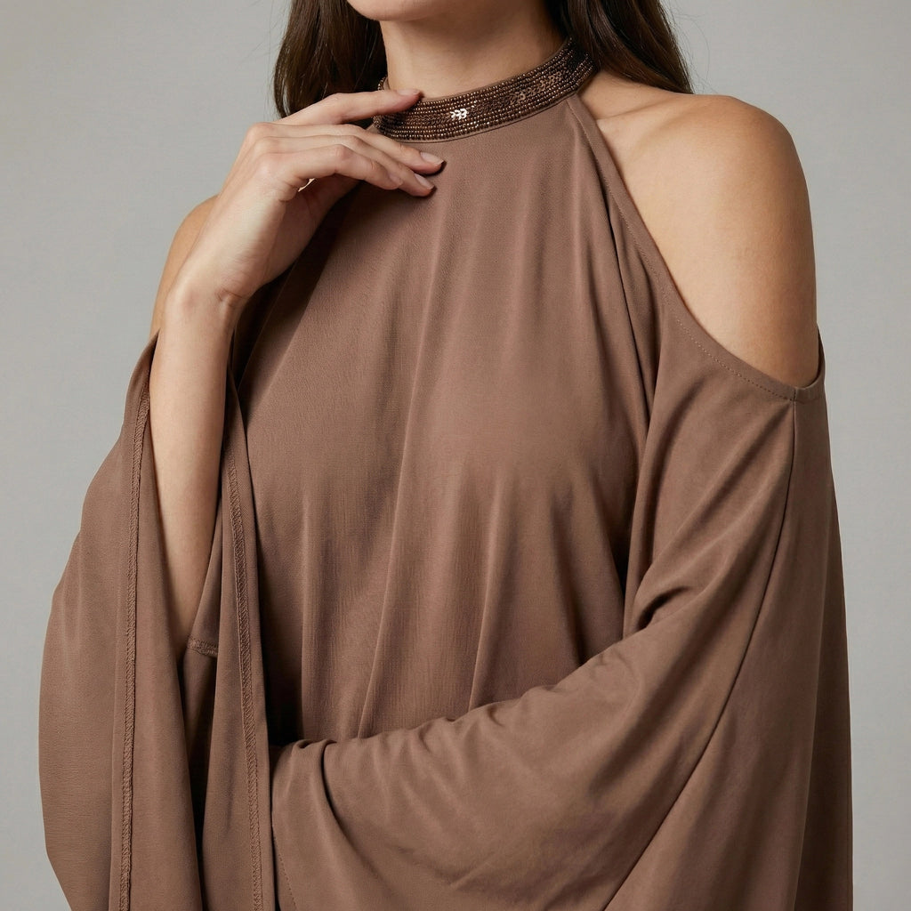 Brown long-sleeve top with cut-out shoulders on a gray background