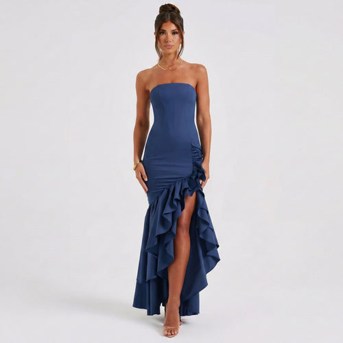 Woman wearing a strapless blue evening gown with a slit on a white background