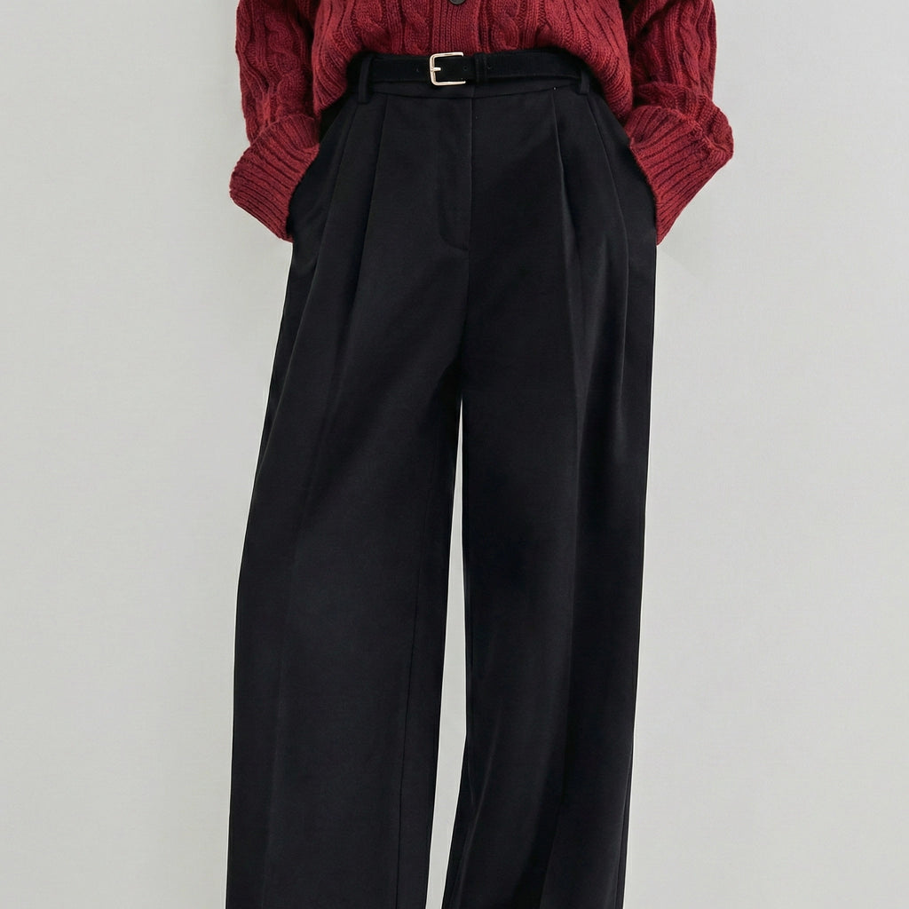 Black wide-leg pants worn with a red knitted sweater on a light gray background