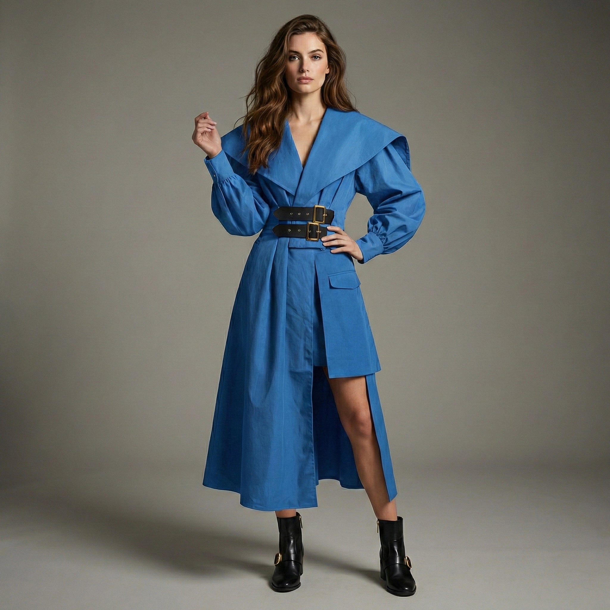 Woman wearing a blue dress with a belt against a gray background