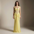 Woman wearing a yellow evening gown against a neutral background