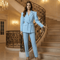 Woman in a light blue suit standing on a staircase in an elegant interior setting