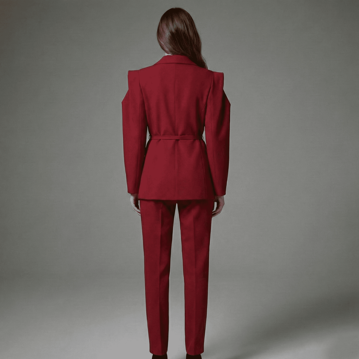 Person wearing a red suit against a gray background