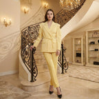 Woman in a yellow suit standing on a staircase in an elegant interior setting