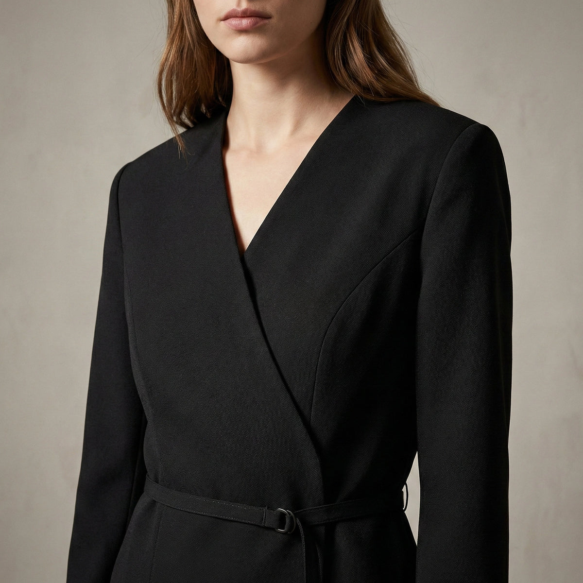 Black wrap dress worn by a person on a neutral background