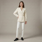 Woman wearing a cream-colored suit with a plain background