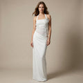Woman wearing a white halter neck gown against a beige background