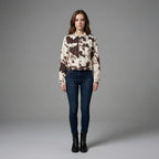 Woman wearing a patterned shirt and jeans on a gray background