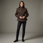 Woman wearing a brown coat and black pants on a gray background