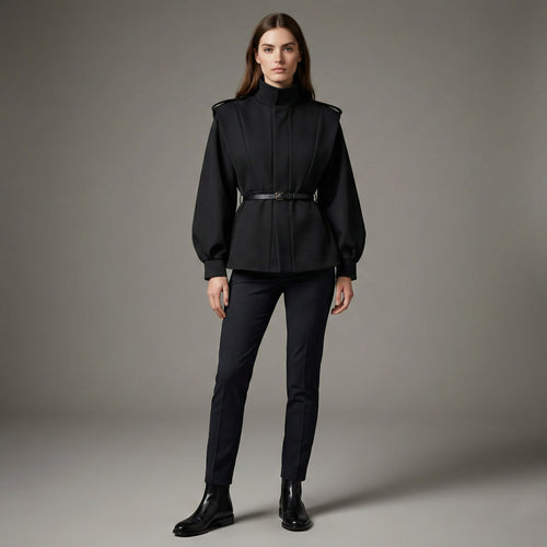 Woman wearing a black outfit with a belt on a gray background