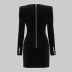 Black dress with gold buttons and zipper on a gray background