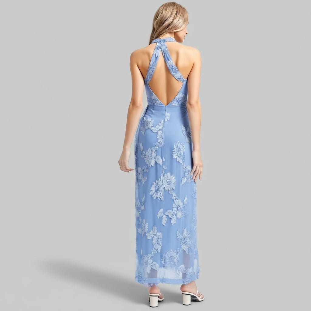 Woman wearing a blue floral dress with an open back on a gray background
