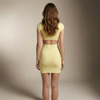 Woman wearing a yellow dress against a neutral background