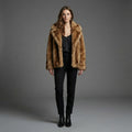 Woman wearing a brown fur coat against a gray background
