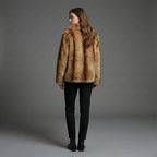 Person wearing a brown fur coat against a gray background