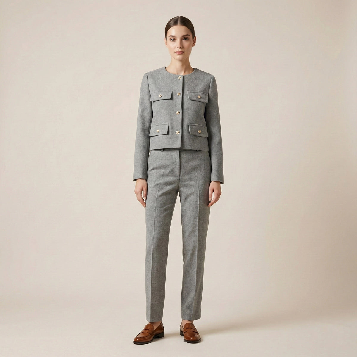 Woman wearing a gray suit with a plain background