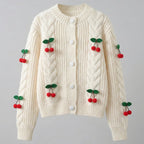 Cream-colored sweater with cherry decorations on a gray background