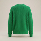 Green knitted sweater on a beige background