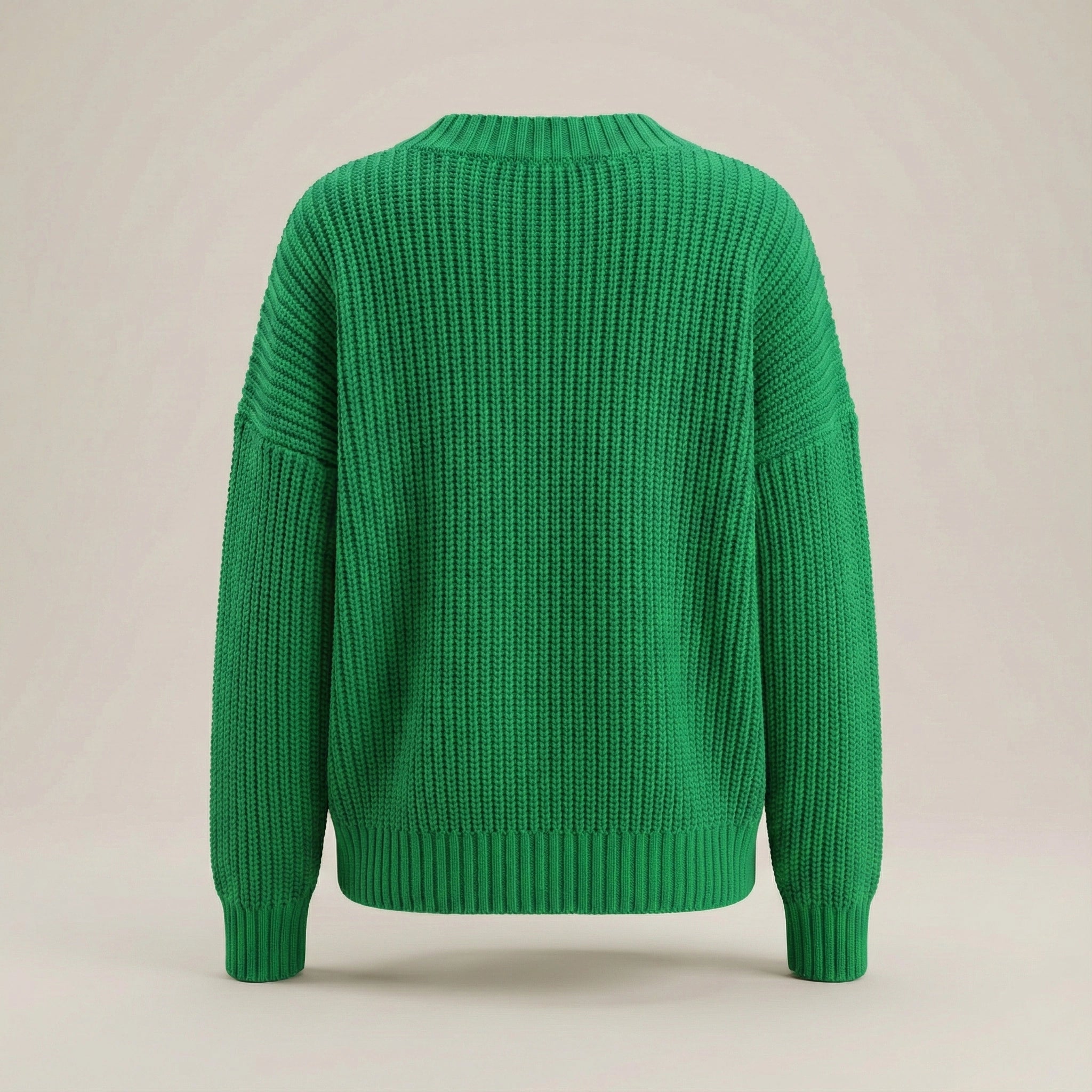 Green knitted sweater on a beige background
