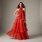 Woman wearing a red tiered gown against a neutral background
