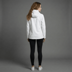 Woman wearing a white jacket and black pants on a gray background