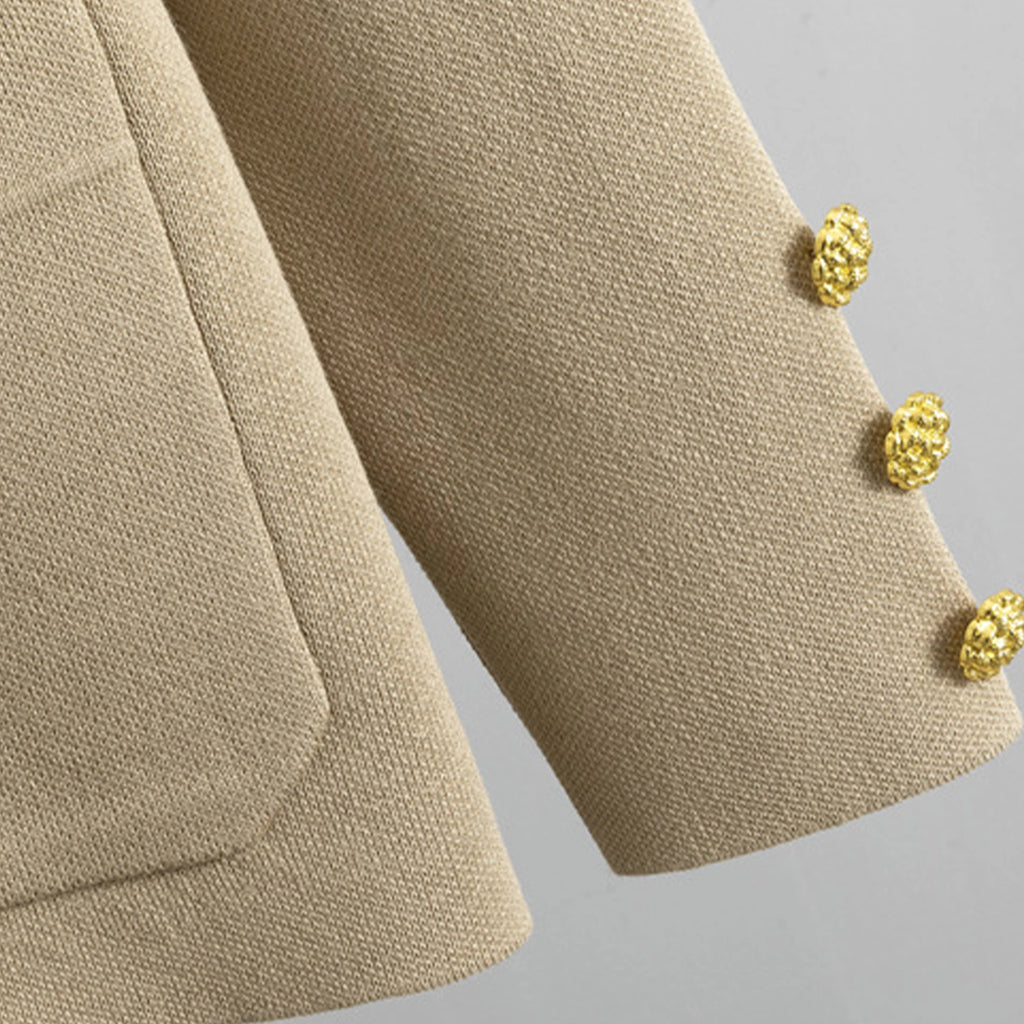 Close-up of a beige textured fabric with gold buttons on a gray background