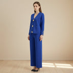 Woman wearing a blue suit with gold buttons on a gray background