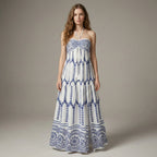 Woman wearing a strapless blue and white patterned dress on a plain background