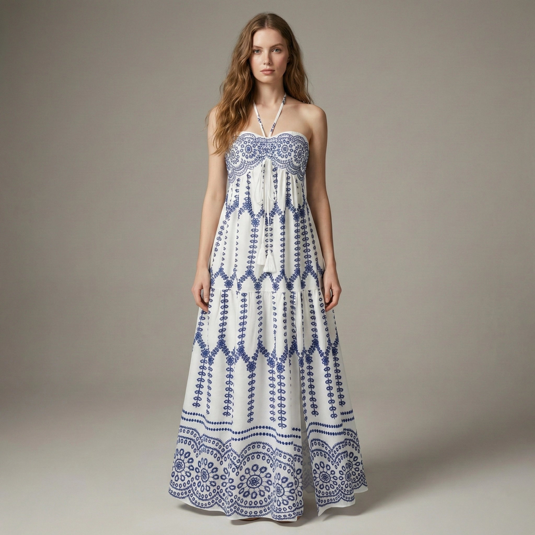 Woman wearing a strapless blue and white patterned dress on a plain background
