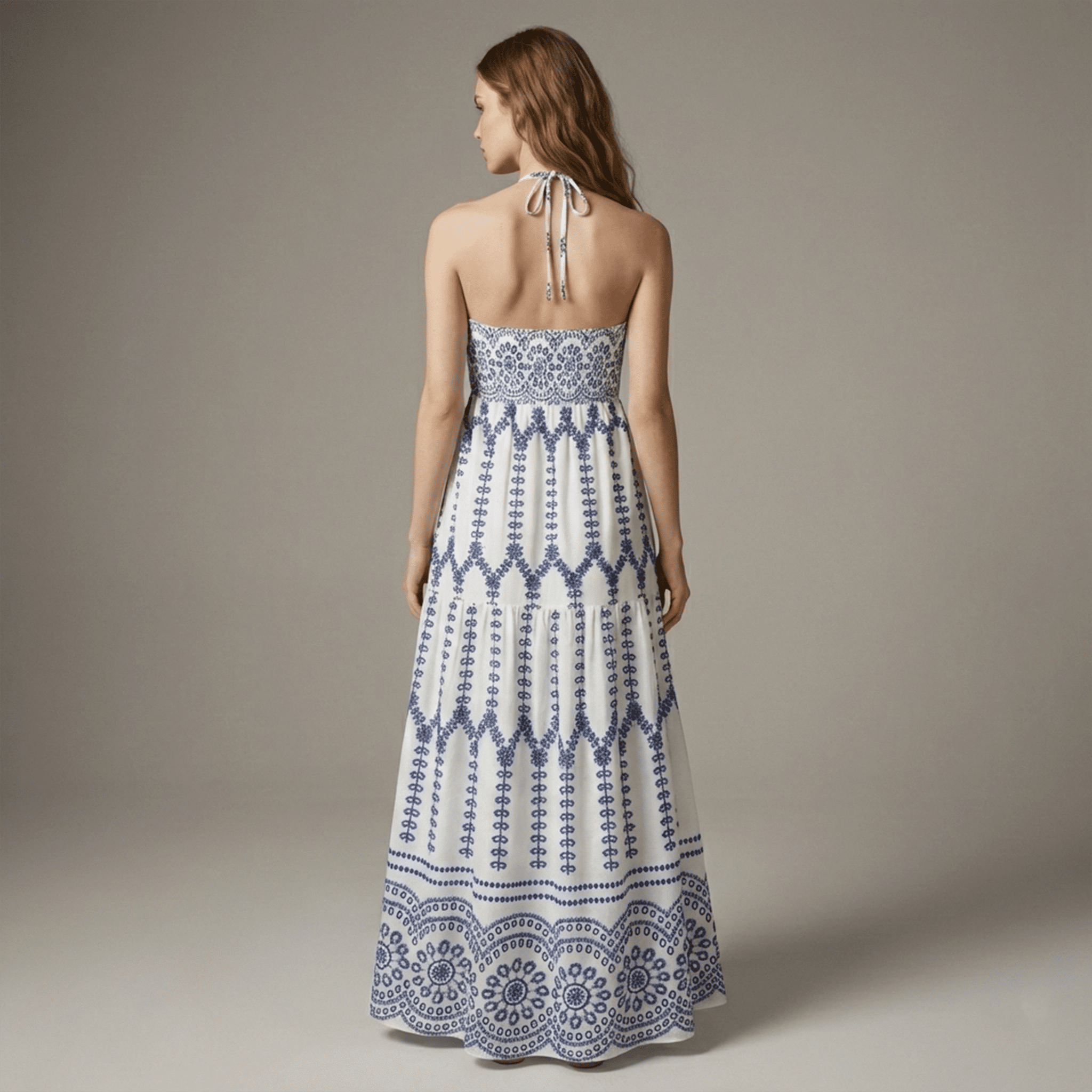 Woman wearing a blue and white patterned dress on a plain background