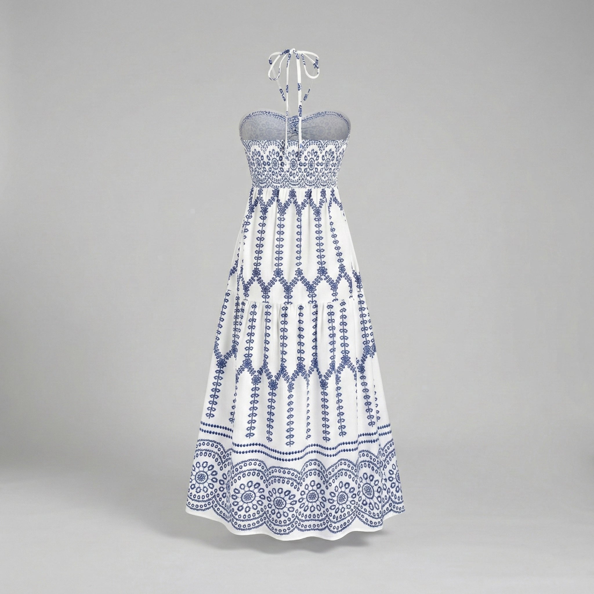 White strapless dress with blue geometric pattern on a gray background