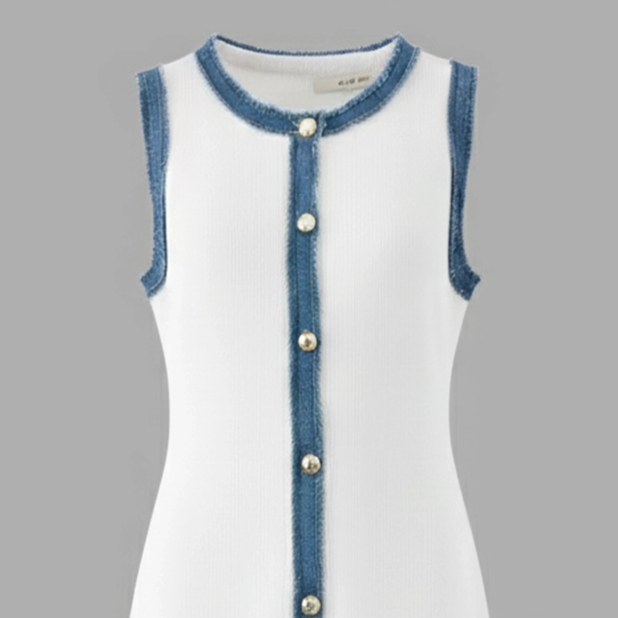 White dress with blue denim trim and buttons on a gray background