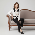 Woman sitting on a vintage-style sofa wearing a black and white outfit.