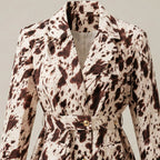Spotted coat with a belt on a neutral background