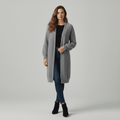 Woman wearing a gray long coat on a plain background