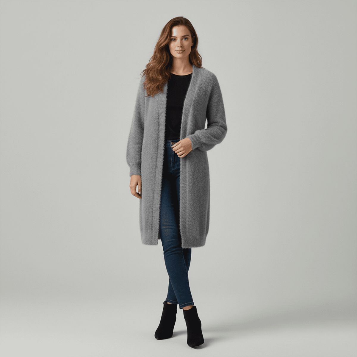 Woman wearing a gray long coat on a plain background