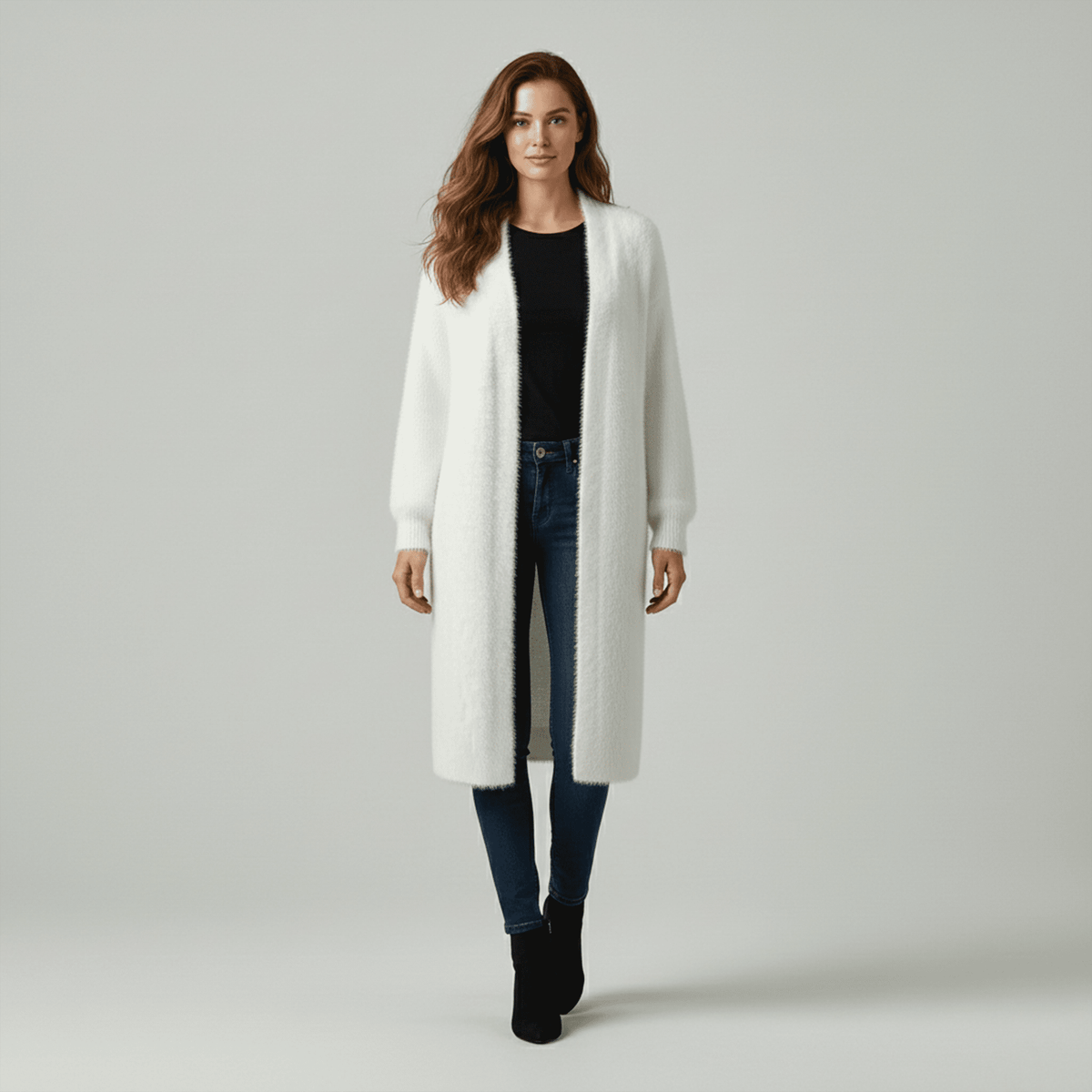 Woman wearing a white long coat on a gray background