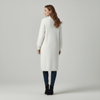 Woman wearing a long white cardigan on a gray background