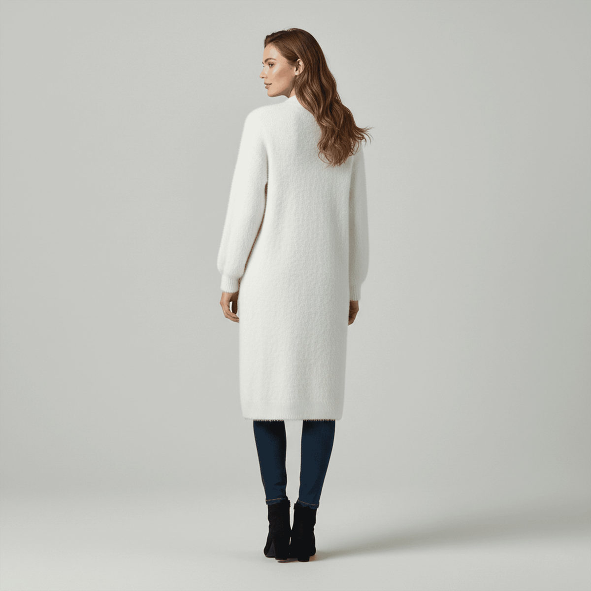 Woman wearing a long white cardigan on a gray background