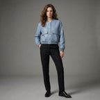 Person wearing a light blue jacket and black pants on a gray background