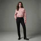 Woman wearing a pink jacket and black pants on a gray background